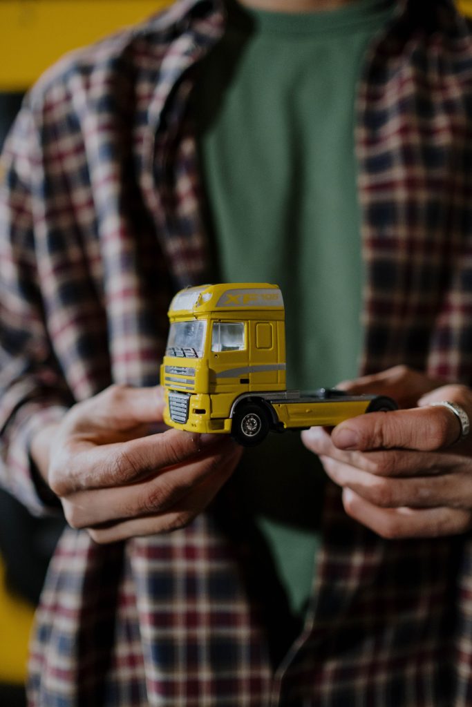 Persona con un camion de juguete en la mano